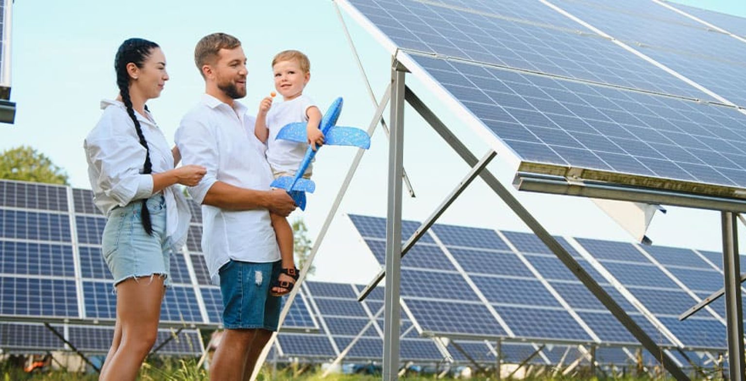 Familia Joven con un bebe paseando entre paneles solares en un campo de endesa